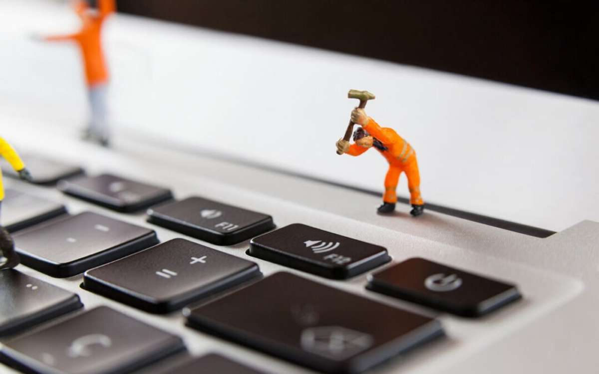 miniature-workmen-repairing-laptop-keyboard